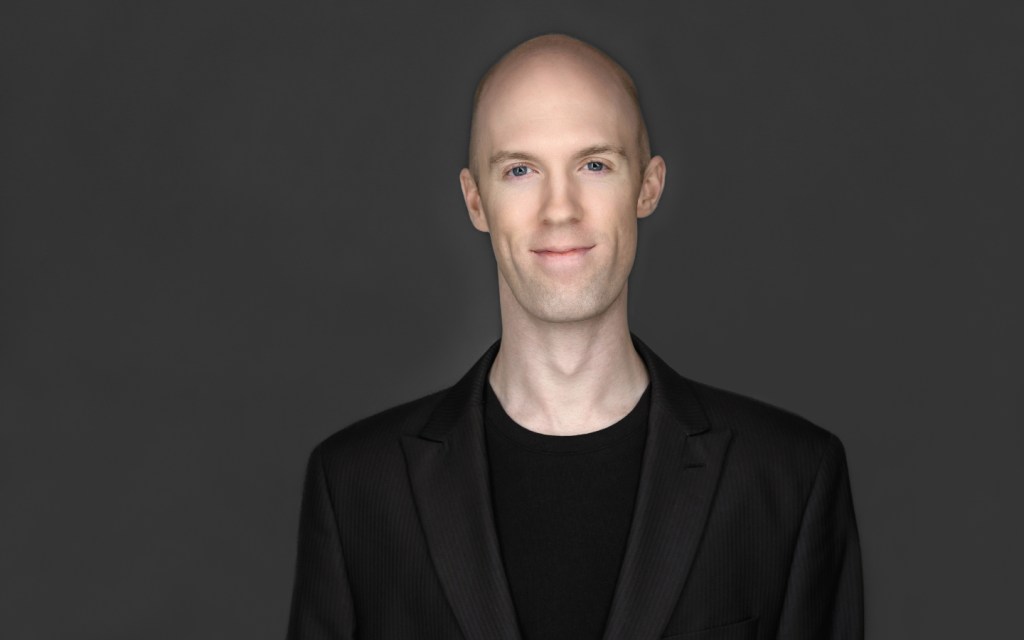 A portrait of nick against a dark background